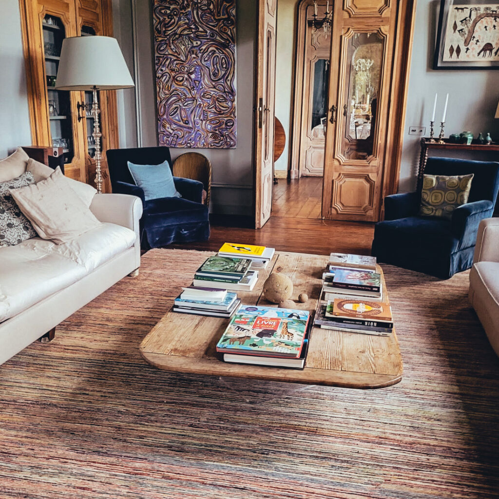 Beau salon moderne composé de 2 grands canapés blancs, un tapis à motif et d'une table basse en bois